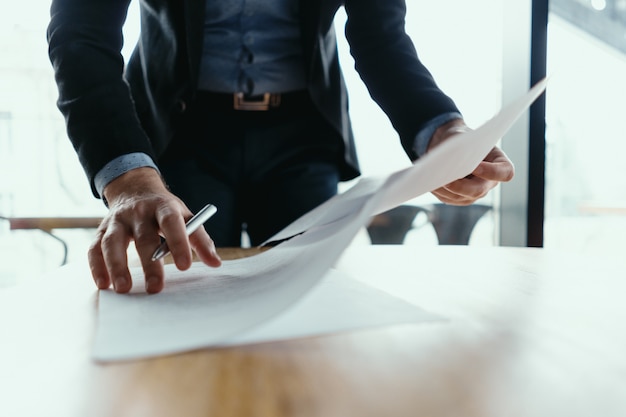 Free photo successful business man signing documents in a modern office