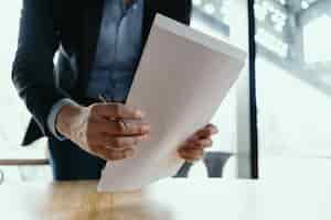 Free photo successful business man signing documents in a modern office