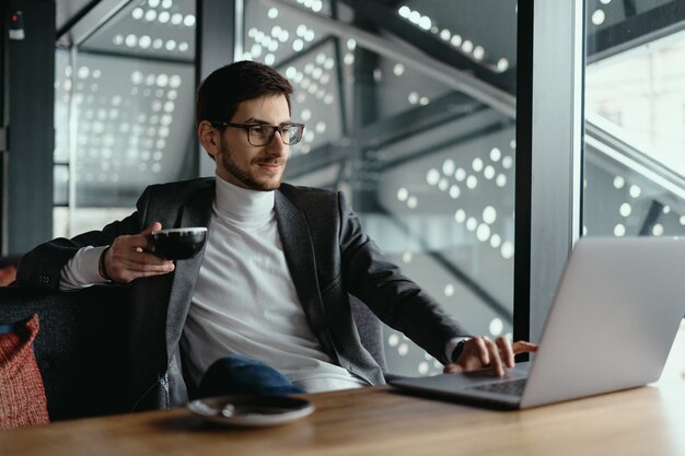 Successful business man working on laptop while drinking coffee