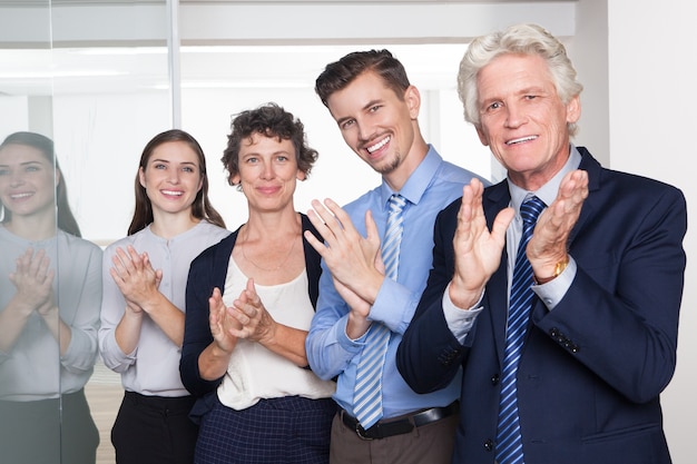 Free photo successful business people smiling and applauding