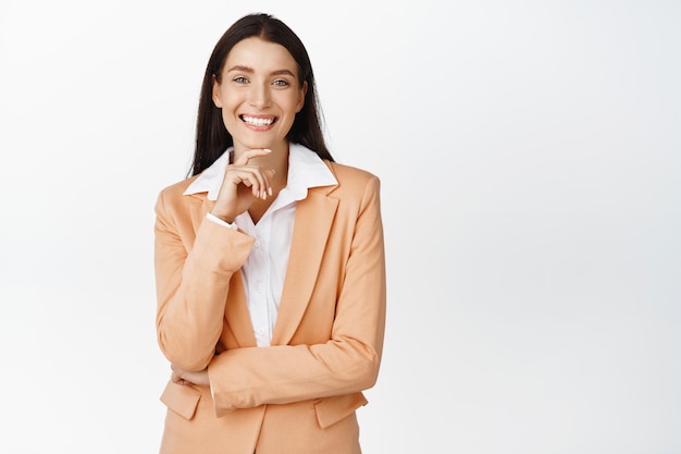 Successful corporate woman smiling looking happy wearing business suit standing against white background