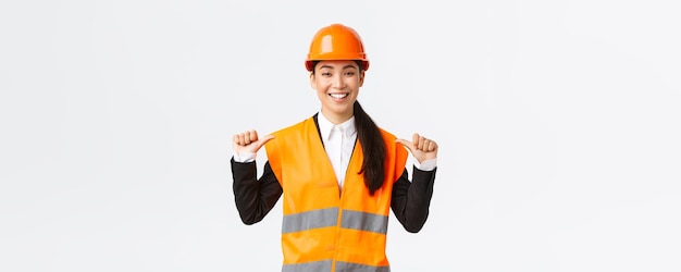 Successful proud smiling asian female construction manager engineer in safety helmet pointing at herself showoff Architect recommend personal assistance bragging accomplishments