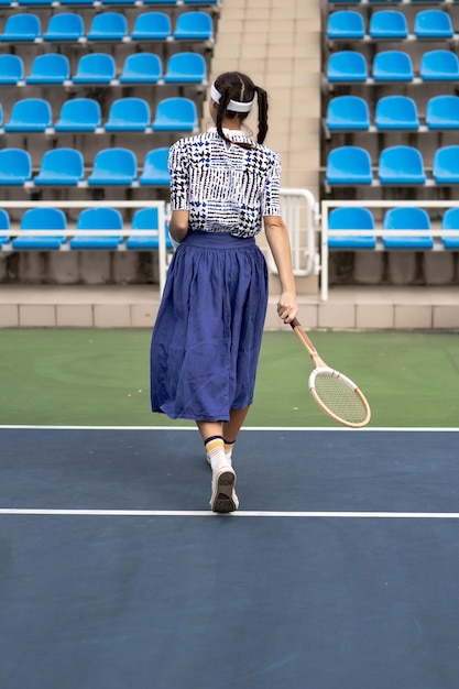 Successful sportswoman with racket at the tennis court. Healthy lifestyle