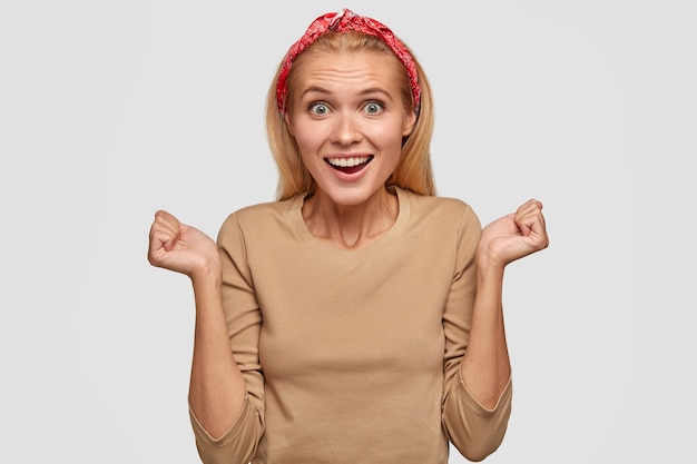 Free photo successful woman with broad shining smile, clenched fists, celebrating success