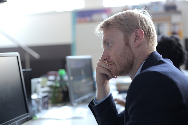 Free Photo successful young businessman looking at the computer screen working in a modern startup office