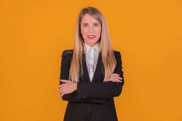 Free Photo successful young businesswoman looking at camera standing against an orange background