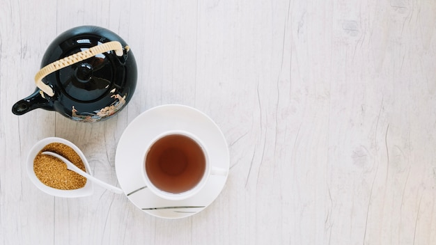 Sugar near cup of tea and teapot