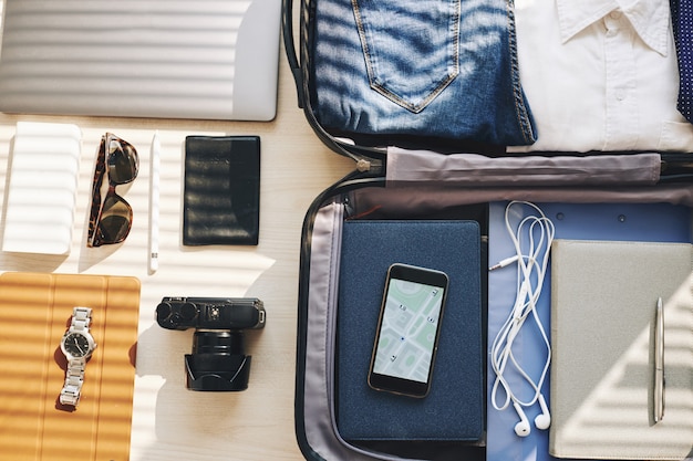 Free photo suitcase, electronic devices and personal belongings arranged for business trip