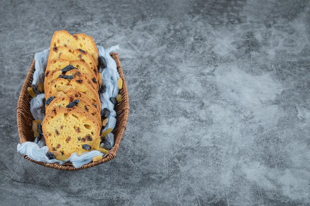 Sultana pie slices on wooden basket on blue towel.