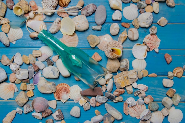 Free photo summer composition with bottle and seashells