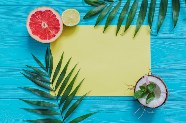 Summer composition with yellow paper and decorative fruits