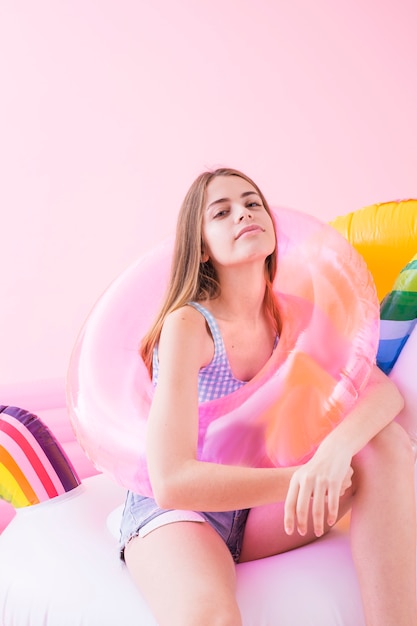 Summer fashion concept with young woman on inflatable unicorn