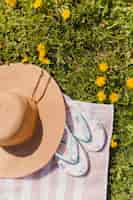 Free photo summer hat with flip flops in the field