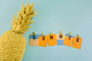 Free photo summer label with clothespin near the painted yellow pineapple on blue background