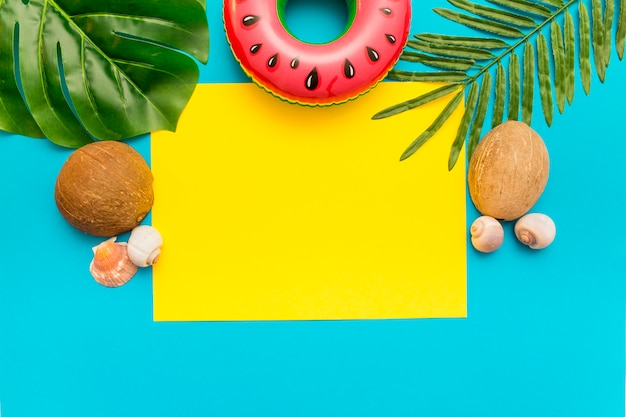 Free photo summer mix with palm leaves and coconut on blue background