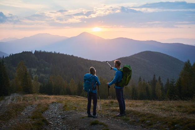 Free photo summer mountain trekking two travelers hiking in the mountains