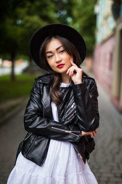 Summer sunny lifestyle fashion portrait of young asian woman walking on the street, wearing cute trendy outfit