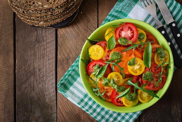 Summer tomato salad with basil, pesto and arugula