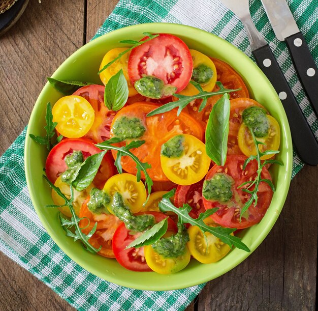 Summer tomato salad with basil, pesto and arugula