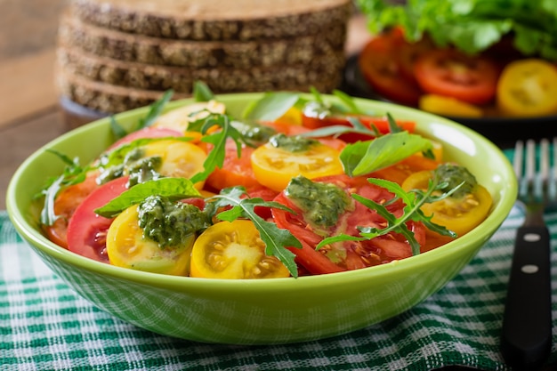 Free photo summer tomato salad with basil, pesto and arugula