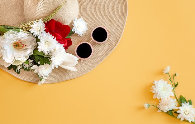 Summer with white flowers and a wicker hat with sunglasses