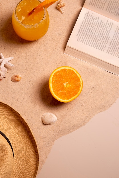 Summertime vibes with book and hat on sand