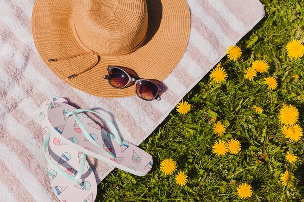 Sunglasses and hat with towel and flip flops