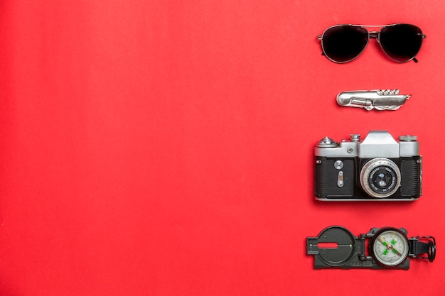 Sunglasses and knife near camera and compass