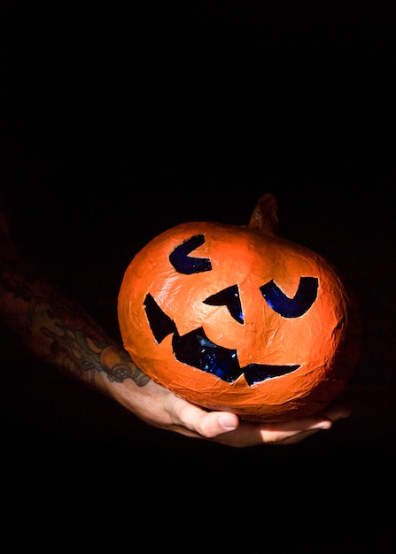 Sunlit pumpkin with carved blue face 