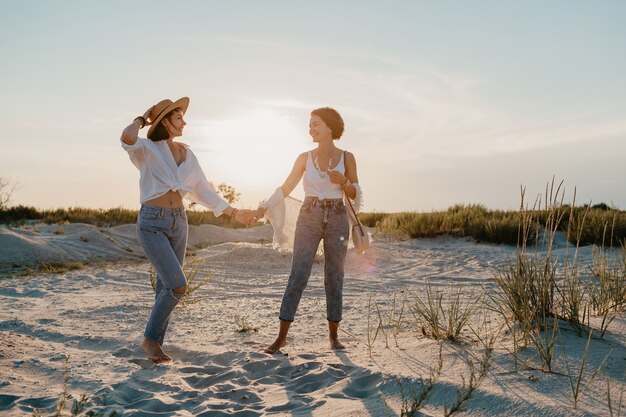 Sunny happy two young women having fun on the sunset beach, gay lesbian love romance