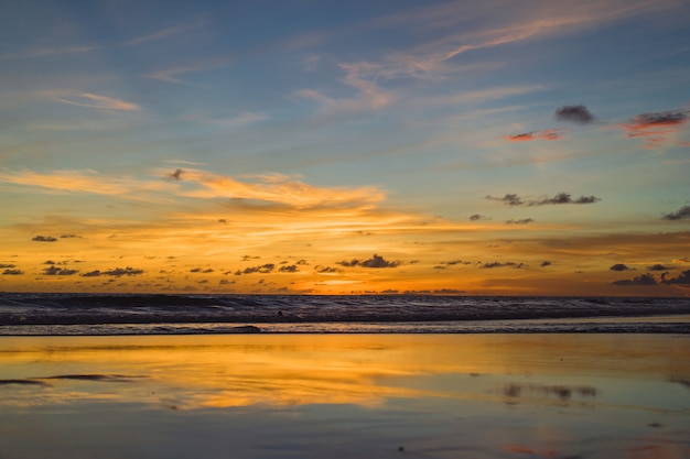 sunset on the ocean. beautiful bright sky, reflection in water, waves.