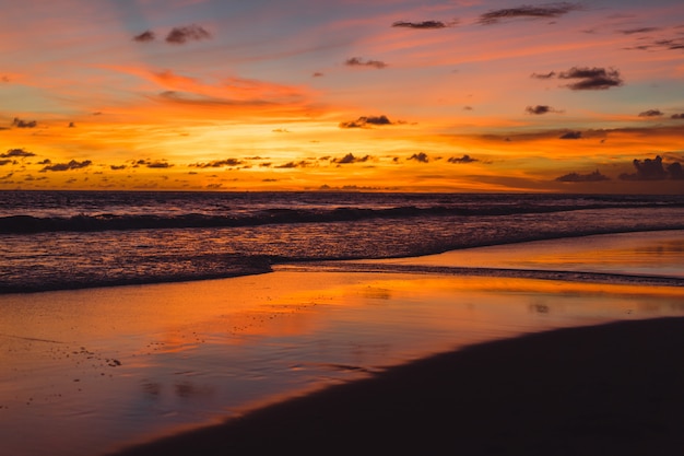 sunset on the ocean. beautiful bright sky, reflection in water, waves.