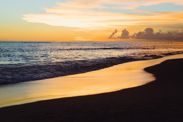 Free photo sunset on the ocean. beautiful bright sky, reflection in water, waves.