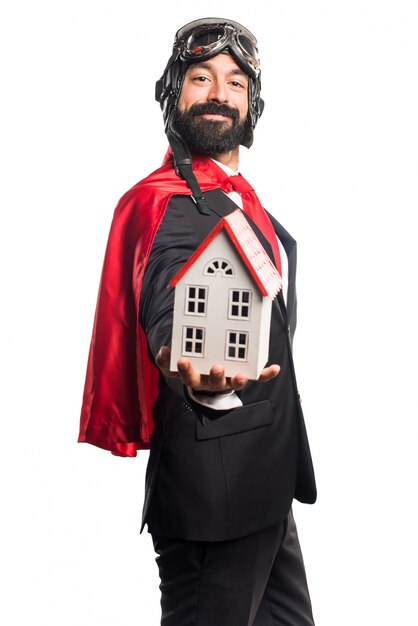 Super hero businessman holding a little house