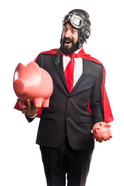 Super hero businessman holding a piggybank