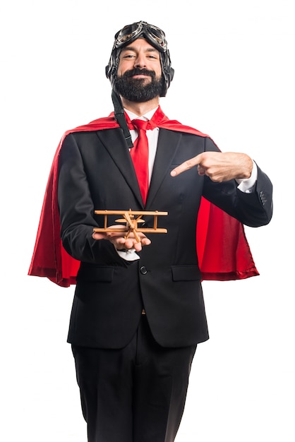 Free photo super hero businessman holding a wooden toy airplane