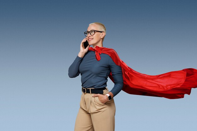 Superwoman with cape talking on smartphone