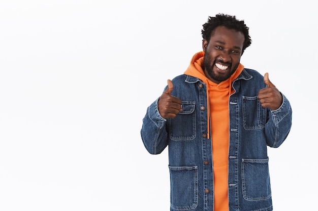 Supportive handsome african-american man showing thumbs-up in like or approval, smiling pleased, rooting for you or give his positive reply