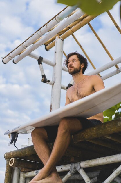 Surfboard Surfer Outdoor Sport Tropical Ocean Concept. Young handsome man with a surfboard on the ocean.