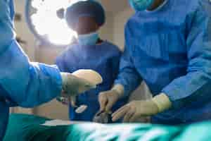 Free photo surgeon team in uniform performs an operation on a patient at a cardiac surgery clinic modern medicine a professional team of surgeons health