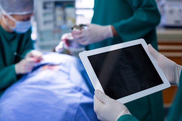 Surgeon using digital tablet while operating patient in operation theater