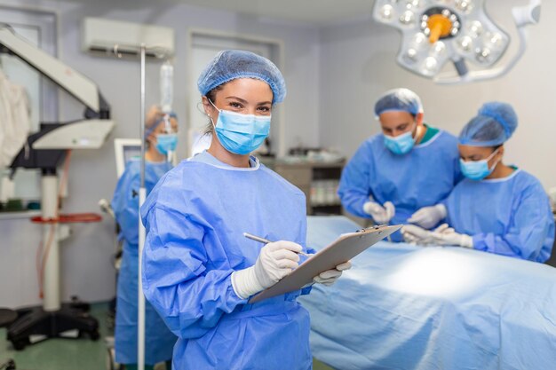 Surgeon writing on clipboard in operation room anaesthesiologist writing the updates