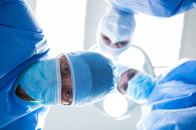 Free photo surgeons looking at camera in operation room