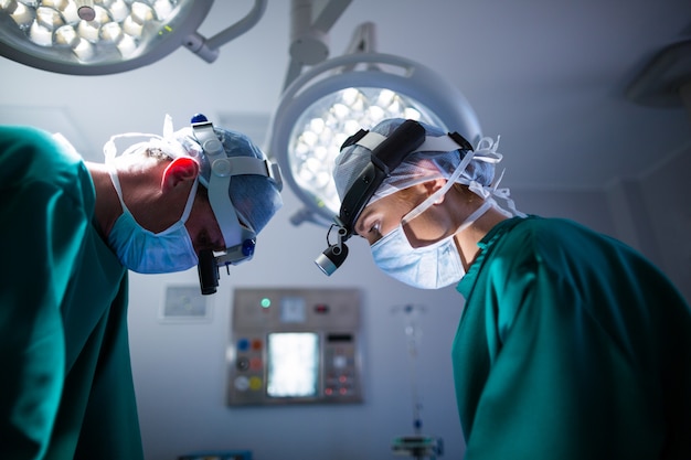 Surgeons wearing surgical loupes while performing operation