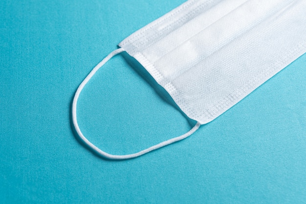 Surgical mask over minimalist blue background