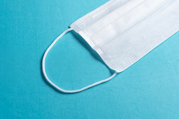 Surgical mask over minimalist blue background