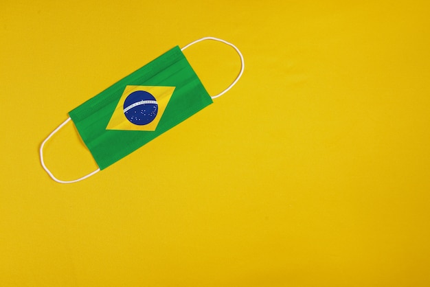 Free photo surgical mask on yellow background with brazilian flag