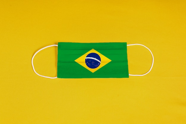 Surgical mask on yellow background with Brazilian flag