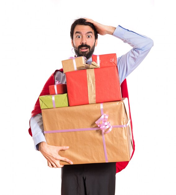 Surprise businessman dressed like superhero holding gifts