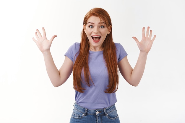 Free photo surprise celebration and happiness concept cheerful redhead girl with long ginger hair raising hands up triumphing excited smiling gasping fascinated receive good awesome news white background